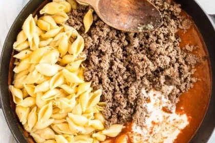 Creamy beef and shells dish served in a white bowl garnished with parsley