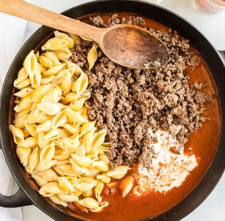 Creamy beef and shells dish served in a white bowl garnished with parsley