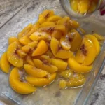 Delicious Peach Cobbler Dump Cake topped with fresh peaches and a crispy crust