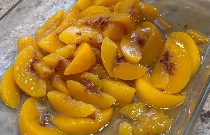 Delicious Peach Cobbler Dump Cake topped with fresh peaches and a crispy crust