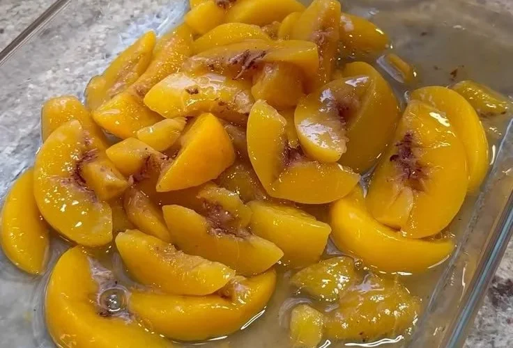 Delicious Peach Cobbler Dump Cake topped with fresh peaches and a crispy crust