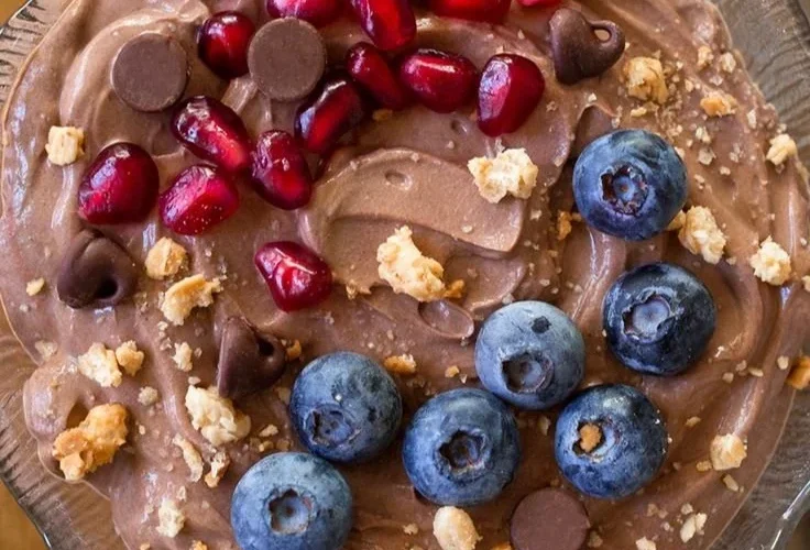 A bowl of fluffy protein fluff topped with berries and nuts.