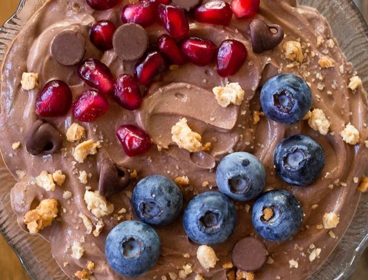 A bowl of fluffy protein fluff topped with berries and nuts.