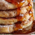 Delicious Spanish churro-inspired pancakes topped with cinnamon sugar and chocolate sauce.