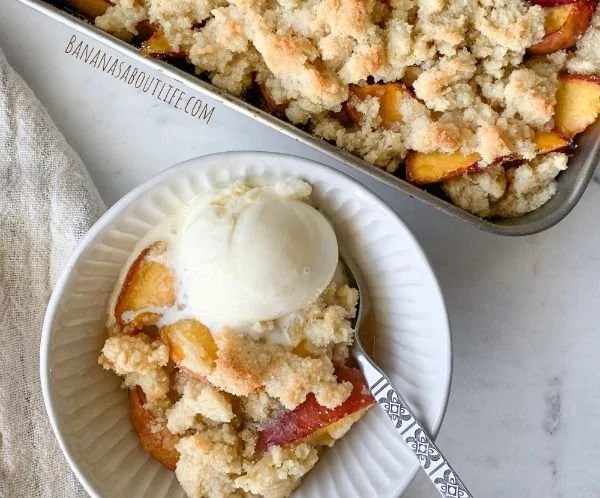 Easy almond flour peach cobbler topped with fresh peaches