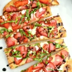 Balsamic strawberry flatbread garnished with fresh strawberries and balsamic glaze