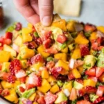 Fresh avocado strawberry mango salsa with colorful ingredients in a bowl