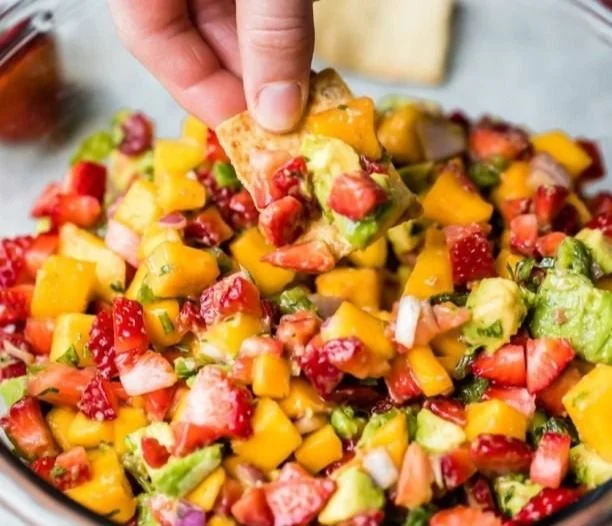 Fresh avocado strawberry mango salsa with colorful ingredients in a bowl