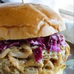 Delicious honey mustard chicken sandwich with shredded chicken and fresh ingredients.