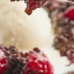 Delicious Black Forest Dump Cake topped with cherries and whipped cream
