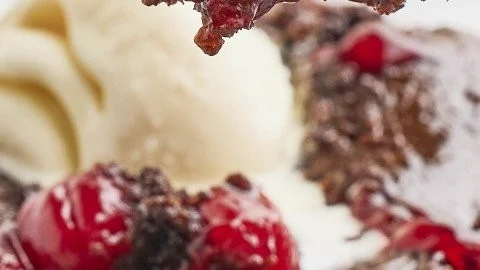 Delicious Black Forest Dump Cake topped with cherries and whipped cream