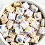 Blueberry lemon cheesecake puppy chow dessert treat in a bowl