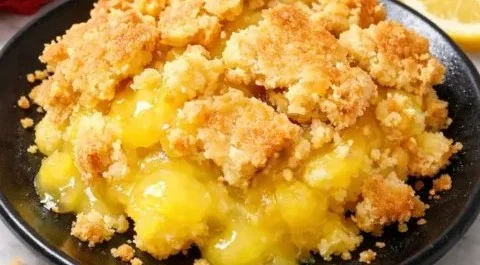 Buttery lemon dump cake slice on a plate