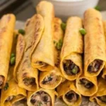 Plate of creamy black bean taquitos with toppings
