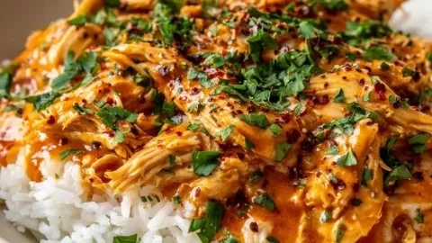 Delicious Crockpot Cajun Butter Chicken served with rice and greens