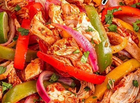 Easy Crockpot chicken fajitas with bell peppers and onions in a slow cooker