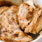 Easy gluten free cinnamon roll in a mug topped with icing