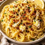 Plate of easy lemon butter ricotta pasta topped with herbs