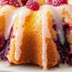 Easy lemon raspberry bundt cake on a white plate garnish with fresh raspberries