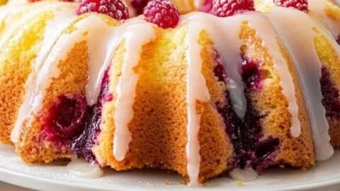 Easy lemon raspberry bundt cake on a white plate garnish with fresh raspberries