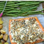 Sheet pan salmon seasoned with everything bagel spices on a baking sheet.