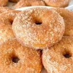 Gluten-free apple cider donuts displayed on a rustic wooden table