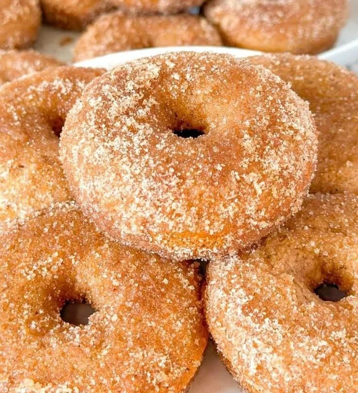 Gluten-free apple cider donuts displayed on a rustic wooden table