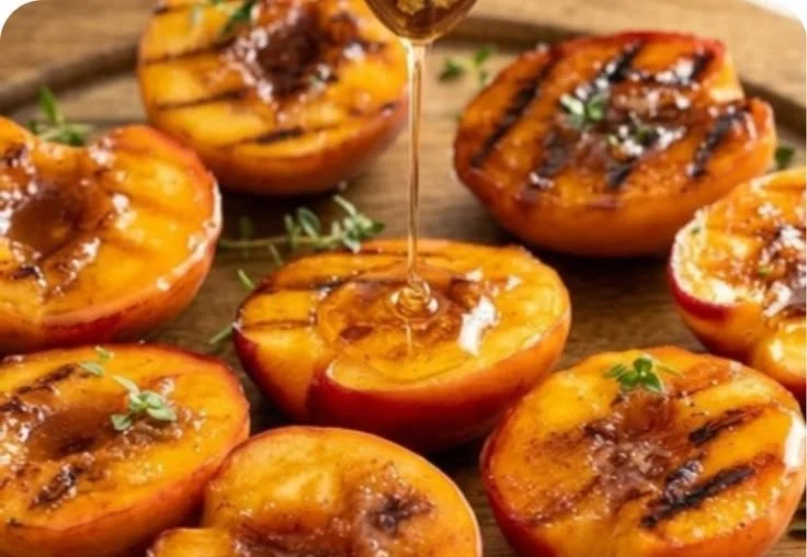 Delicious grilled peaches served with ice cream and drizzled with honey