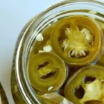 Homemade pickled jalapenos in a jar with spices
