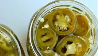 Homemade pickled jalapenos in a jar with spices