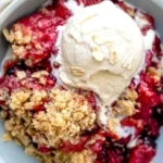 Delicious Mixed Berry Crisp dessert topped with oats and fresh mixed berries