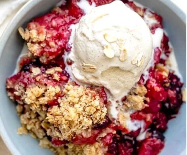 Delicious Mixed Berry Crisp dessert topped with oats and fresh mixed berries