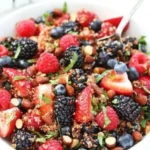 Colorful quinoa fruit salad with fresh fruits and greens