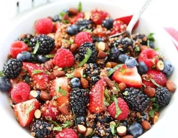 Colorful quinoa fruit salad with fresh fruits and greens