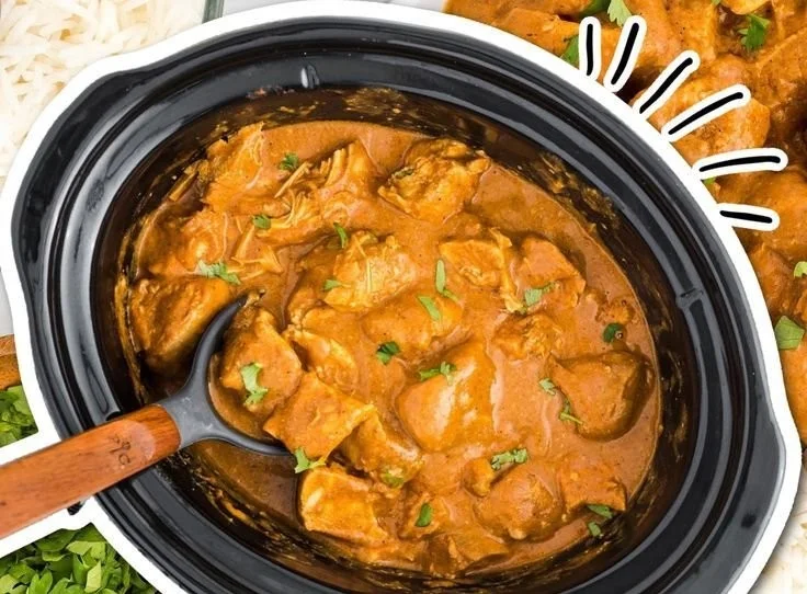 A plate of slow cooker butter chicken served with rice and naan bread.