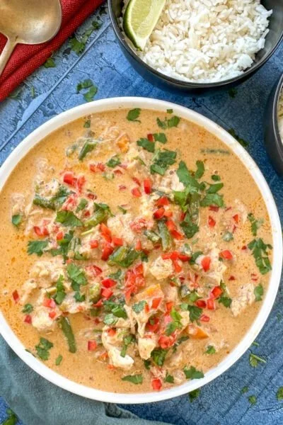Slow cooker chicken served with vegetables and herbs in a bowl