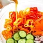 Bowl of spicy Asian salad with colorful vegetables and dressing