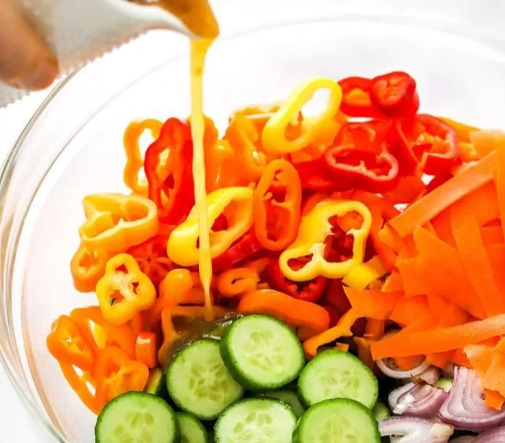 Bowl of spicy Asian salad with colorful vegetables and dressing