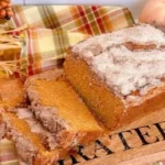 Freshly baked Sweet Potato Bread on a wooden table, garnished with herbs.