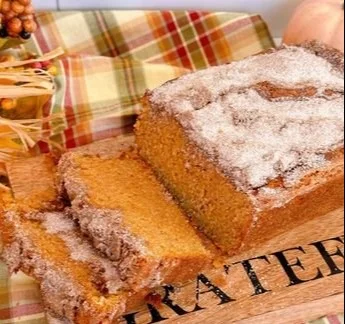 Freshly baked Sweet Potato Bread on a wooden table, garnished with herbs.