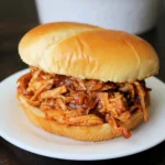 Delicious Crockpot BBQ Chicken served in a bowl with sauce and herbs