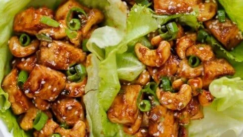 Delicious tofu lettuce wraps with fresh vegetables and sauce on a plate.