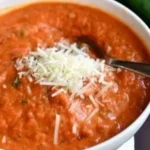 Bowl of delicious zucchini tomato soup garnished with fresh herbs