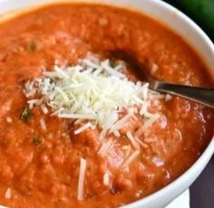 Bowl of delicious zucchini tomato soup garnished with fresh herbs