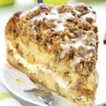 Delicious apple coffee cake with cream cheese filling on a wooden table