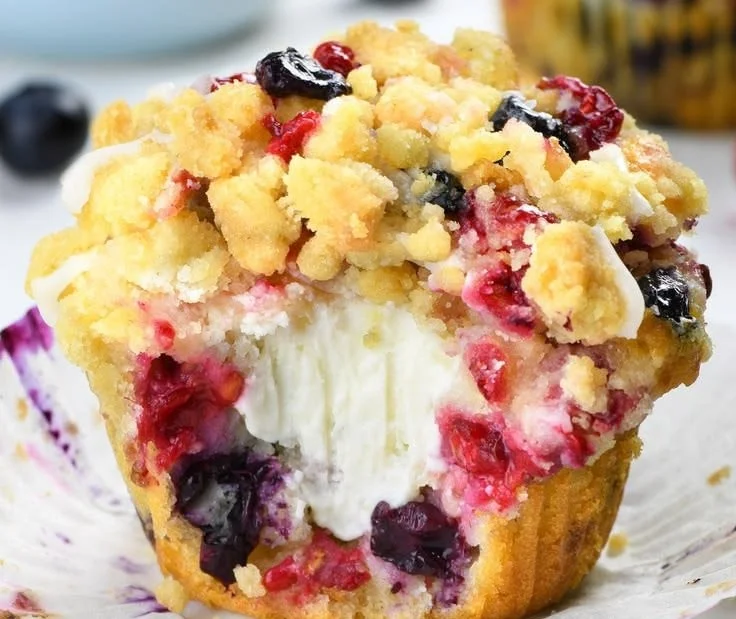 Delicious summer berry cream cheese muffins on a wooden table