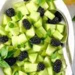A delicious Blackberry Honeydew Salad with fresh basil garnished elegantly.
