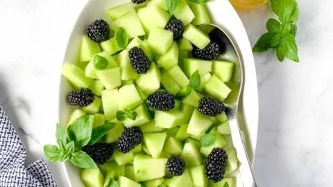 A delicious Blackberry Honeydew Salad with fresh basil garnished elegantly.