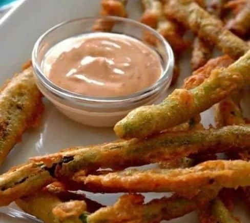 Crispy fried green beans served with a side of sriracha mayo.