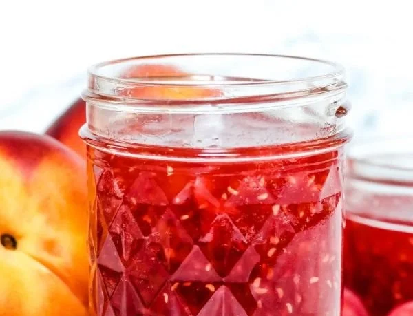 Homemade easy raspberry peach jam in a glass jar